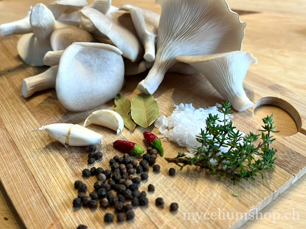 Pleurotes blancs avec ail, laurier, sel, poivre et thym pour conservation au vinaigre